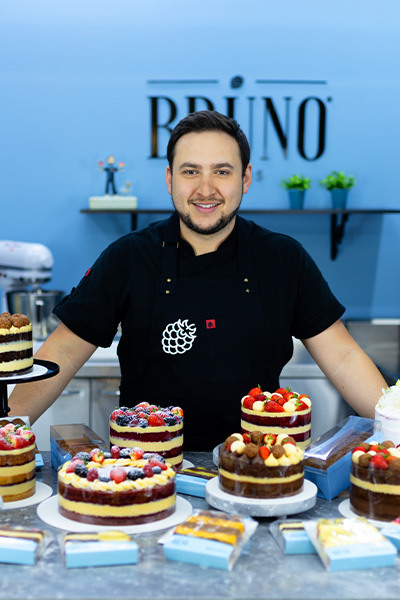Bruno Bolos segurando bolo na cozinha